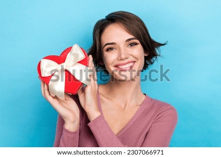 Photo of charming girl wear pink shirt hold heart symbol package gift box receive surprise valentine day isolated on blue color background