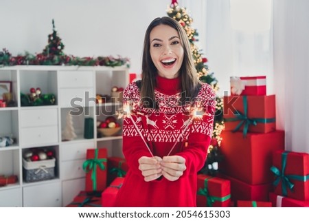 Photo of charming lady hold two bengal fire congratulation concept wear santa hat sweater in decorated x-mas home indoors