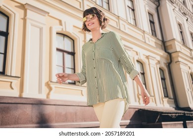 Photo Of Charming Lovely Positive Lady Shiny Smile Walk Wear Sunglass Striped Shirt Pants Urban City Outside