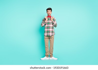 Photo of charming man pout lips hands hold tie look camera wear plaid shirt pants footwear isolated blue color background - Powered by Shutterstock