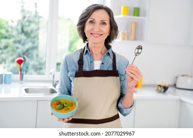 Photo Of Charming Positive Old Lady Hold Hand Spoon Bowl Soup Good Mood Indoors Inside House Home Kitchen