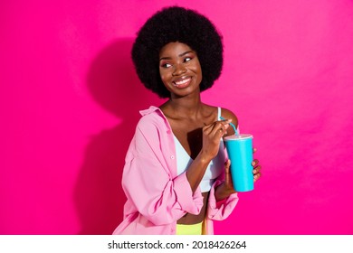 Photo Of Charming Pretty Dark Skin Lady Wear Casual Shirt Drinking Soda Looking Empty Space Smiling Isolated Pink Color Background