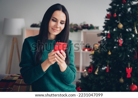 Photo of charming pretty lady dressed knitted x-mas sweater chatting instagram twitter telegram indoors house room