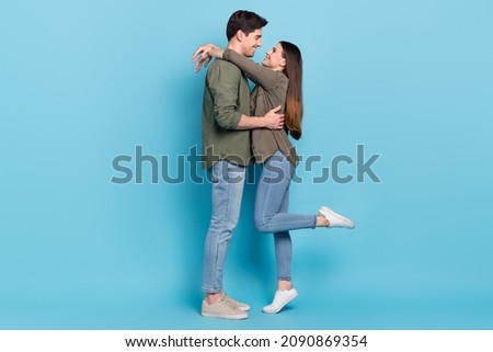Photo of charming shiny young guy woman dressed khaki shirts smiling embracing isolated blue color background