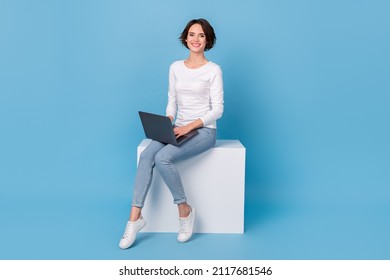 Photo of charming sweet lady dressed white shirt typing modern device sitting platform chair isolated blue color background - Shutterstock ID 2117681546