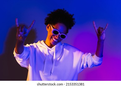 Photo Of Charming Sweet Woman Wear Sweatshirt Dark Eyeglasses Dancing Showing Heavy Rock Isolated Violet Color Background