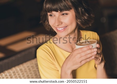 Photo of charming sweet young lady dressed yellow t-shirt sitting cafeteria drinking beverage smiling outdoors urban park