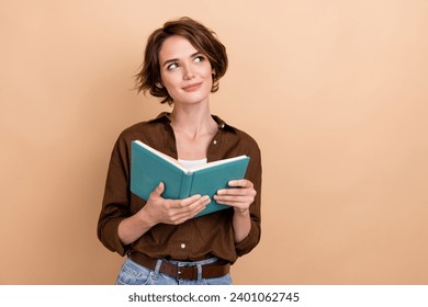 Photo of charming thoughtful lady wear brown shirt enjoying good story looking empty space isolated beige color background - Powered by Shutterstock