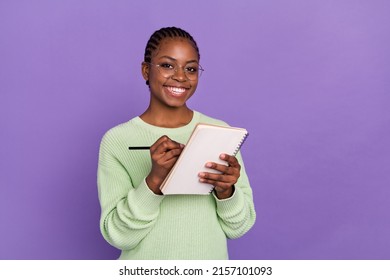 Photo Of Charming Young Female Working As Journalist Writing An Essay In Notebook Isolated On Violet Color Background