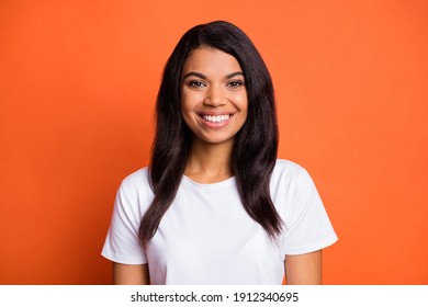 Photo of charming young lady toothy smile look camera wear white t-shirt isolated orange color background