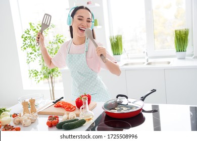 Photo Of Cheerful Asian Ethnicity Housewife Cutting Salad Cooking Tasty Breakfast Listening Cool Wireless Headphones Sing Table Spoon Favorite Song Stand Modern Kitchen Indoors