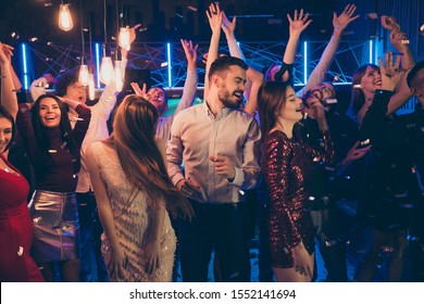 Photo of cheerful attractive beautiful students dressed in formalwear celebrating brithday of his friend surrounded by girls feeling carefree washed with neon light turned by dj