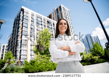 Photo of cheerful attractive woman crossed arms dressed stylish shirt glasses walking city center weekend sunshine