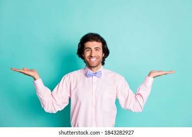 Photo Of Cheerful Brunet Curly Man Wear Pink Outfit Offer Compare Two Things Empty Space Isolated Turquoise Color Background