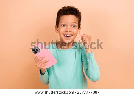 Photo of cheerful cute funky boy wear trendy clothes showing fist hands black friday sale device shop isolated on beige color background