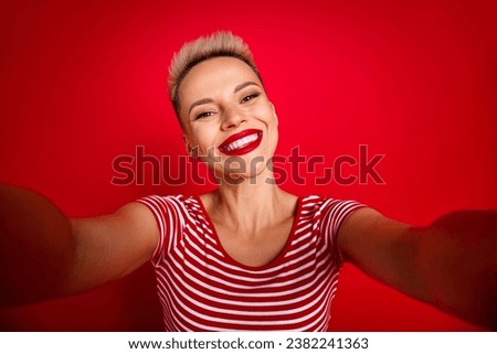 Photo of cheerful cute girl wearing trendy clothes shooting recording video vlog isolated on red color background