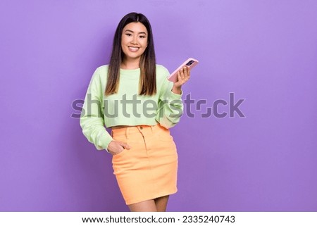 Photo of cheerful cute lady wear green sweatshirt texting modern gadget empty space isolated purple color background