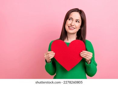 Photo of cheerful dreamy woman wear green sweater rising heart looking emtpy space isolated pink color background
