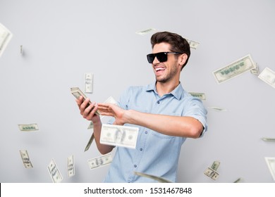 Photo of cheerful excited ecstatic overjoyed man throwing money away showing his wealthiness wearing denim isolated over grey color background