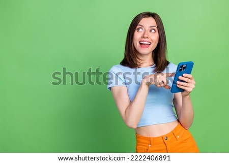 Photo of cheerful excited person finger touch telephone look empty space isolated on green color background