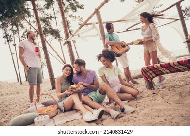 Photo of cheerful friends sit plaid sit picnic plaid enjoy meal sandwich wear casual clothes nature summer seaside beach - Powered by Shutterstock