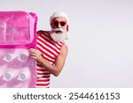 Photo of cheerful funky santa claus wear red swimwear sea resort hold inflatable mat empty space isolated on white color background