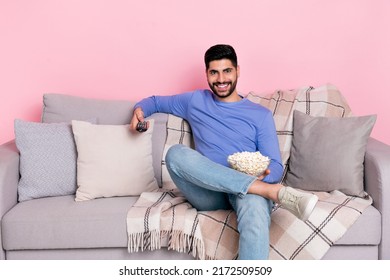 Photo Of Cheerful Funny Guy Sitting Couch Hold Pop Corn Bowl Remote Control Isolated On Pink Color Background