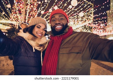 Photo of cheerful funny husband wife wear winter season clothes tacking selfie xmas market urban city street