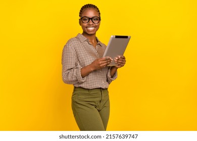 Photo of cheerful funny lady dressed checkered shirt spectacles typing modern device isolated yellow color background - Powered by Shutterstock