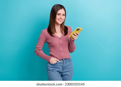 Photo of cheerful girl dressed pink cardigan hold smartphone twitter facebook whatsapp instagram isolated on blue color background