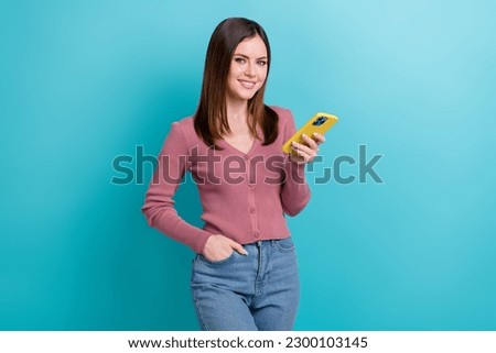Photo of cheerful girl dressed pink cardigan hold smartphone twitter facebook whatsapp instagram isolated on blue color background