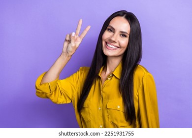 Photo of cheerful glad lady wear trendy clothes demonstrate v-sign good mood isolated on purple color background
