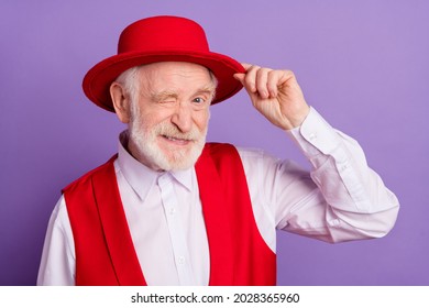 Photo Of Cheerful Happy Charming Old Man Wink Eye Wear Red Hat Smile Isolated On Purple Violet Color Background