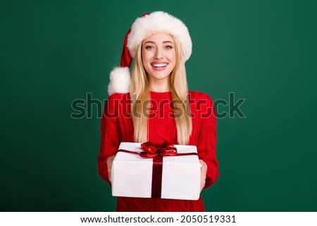 Photo of cheerful happy nice woman hold hands gift box smile christmas celebrate isolated on green color background