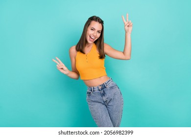 Photo of cheerful happy nice young woman make fingers two v-signs smile enjoy isolated on teal color background