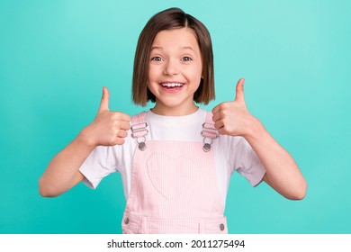 Photo cheerful happy young small girl make fingers thumbs up smile recommend isolated teal color background