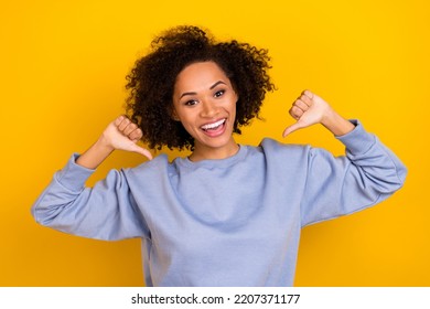 Photo of cheerful impressed curly girl dressed blue pullover pointing thumbs herself isolated yellow color background - Shutterstock ID 2207371177