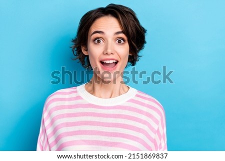 Photo of cheerful impressed young woman open mouth hear good positive news isolated over blue color background