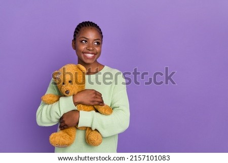 Photo of cheerful lovely lady feeling comfortable with her favorite teddybear toy isolated on purple color background
