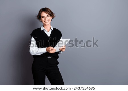 Photo of cheerful lovely lady financier wear stylish outfit use ipad report presentation empty space isolated on gray color background
