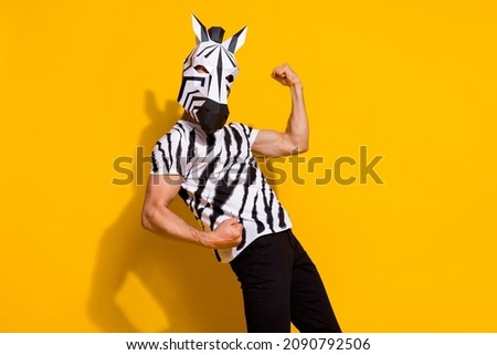 Photo of cheerful lucky guy dressed wild animal costume rising fists celebrating shopping sale isolated yellow color background