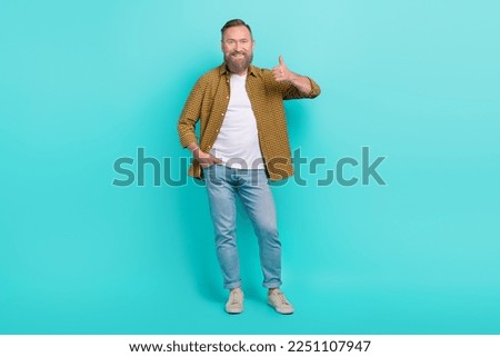 Photo of cheerful man wear fashionable clothes arm thumb up satisfied nice quality empty space isolated on cyan color background