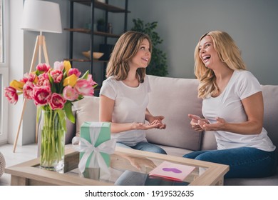 Photo Of Cheerful Mom And Daughter Sit Couch Speak Smile Celebrate Spring Holiday Indoors Inside House