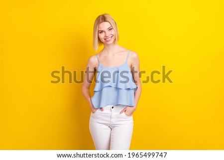 Photo of cheerful nice blond short hair lady stand wear blue top isolated on vivid yellow color background