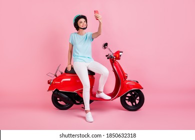 Photo of cheerful nice young woman sit moped talk telephone wear pants shoes slam t-shirt isolated on pastel pink background - Powered by Shutterstock