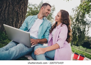 Photo Of Cheerful Positive Boyfriend Girlfriend Wear Casual Outfits Typing Modern Gadget Enjoying Sunny Weather Outdoors Garden