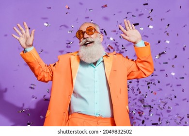 Photo of cheerful positive joyful cool old man confetti fall look copyspace dream isolated on violet color background