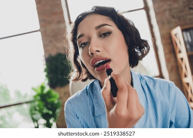 Photo of cheerful positive lady recruiter dressed shirt applying makeup lipstick indoors workplace workstation loft - Powered by Shutterstock