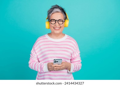 Photo of cheerful positive lady wear striped sweater headphones chatting modern device empty space isolated turquoise color background - Powered by Shutterstock