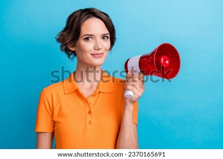Photo of cheerful positive lady wear orange t-shirt smiling rising loud speaker isolated blue color background